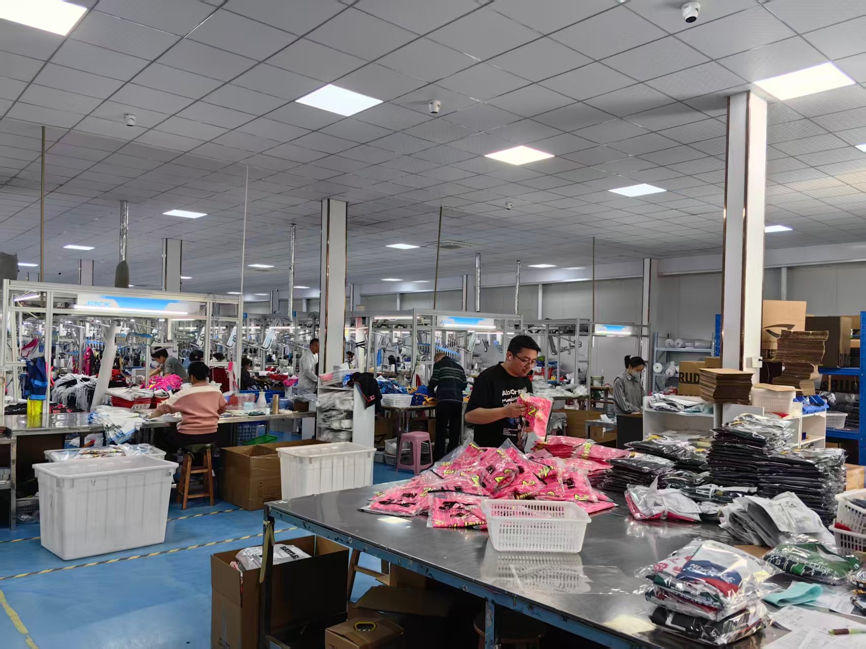 AQL 2.5 检验台与成品经期内裤,汕头生产站点:员工在不锈钢检验台前逐件核对粉色独立包装成品