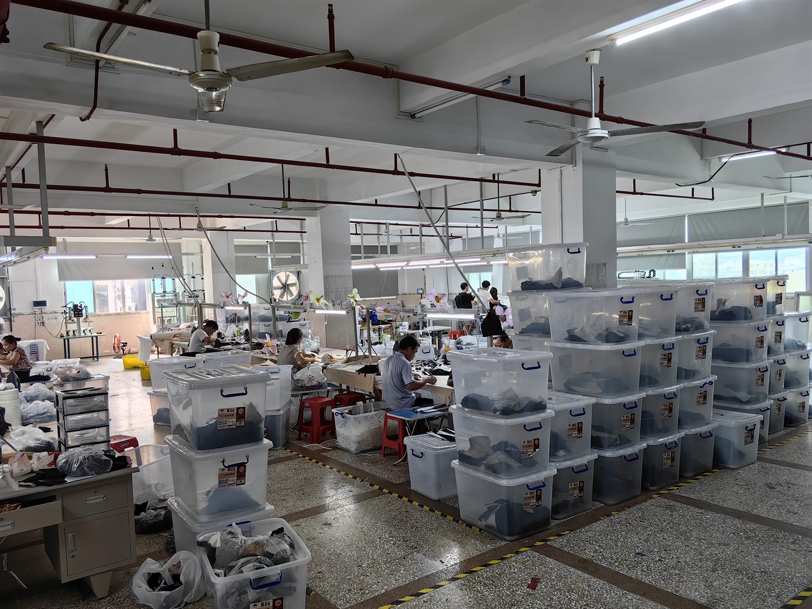 LJVOGUES 车间裁片与半成品周转区实拍:透明周转箱按工序分类码放,箱体贴批次标签